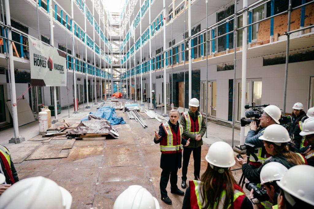 Prime Minister of Canada Mark Carney standing in residential building courtyard